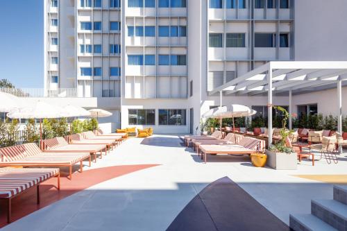 a hotel patio with lounge chairs and umbrellas at Hotel Acta Moa in Lisbon
