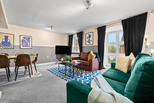 a living room with a green couch and a table at Chic 5-bedroom House in Basingstoke with Parking by PureStay in Basingstoke