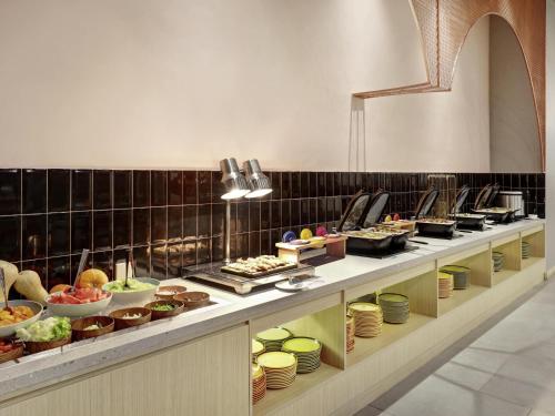 a buffet line with many different types of food at ibis Styles Bogor Pajajaran in Bogor
