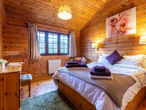 a bedroom with a bed in a log cabin at 1 Bed in Clovelly 00355 in Clovelly
