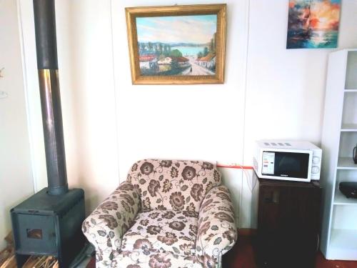 a living room with a chair and a painting at Cabaña Económica Low Cost Independiente Veinte mil x persona Veintiocho mil x dos Valor total por noche Bienvenidos in Valdivia