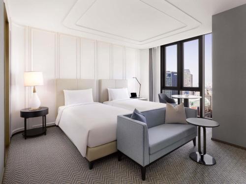 a hotel room with a bed and a chair at Sofitel Ambassador Seoul Hotel & Serviced Residences in Seoul