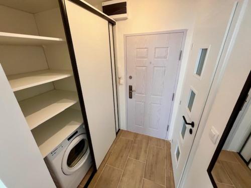 a small closet with a door and a washing machine at Apartmán Dona in Veľký Meder