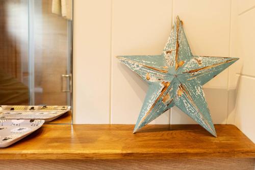 een ster die op een tafel zit naast twee afstandsbedieningen bij Great Gable Riverside Luxury Lodge in Keswick