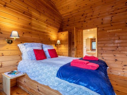 a bedroom with a bed in a wooden cabin at 1 Bed in Clovelly 00354 in Clovelly