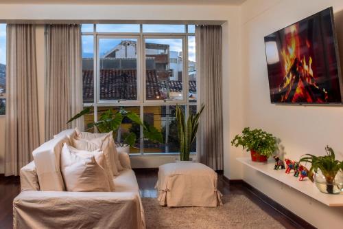 een woonkamer met een bank en een groot raam bij Nuna Atelier in Cuzco