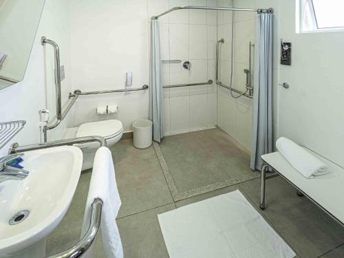 a bathroom with a shower and a sink and a toilet at Ibis Budget Fortaleza Praia de Iracema in Fortaleza