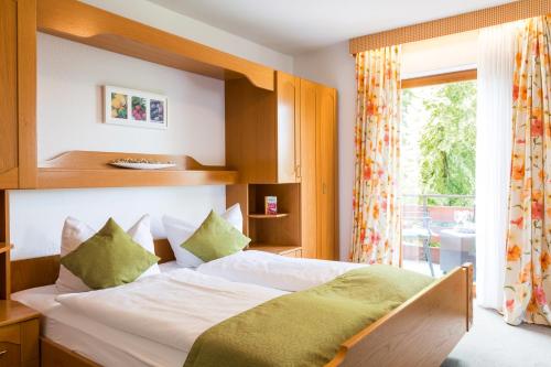 a bedroom with a bed and a large window at Hotel Gasthof Engel in Appenweier