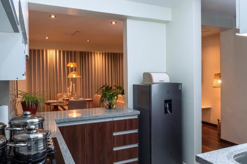 een keuken met een koelkast en een eetkamer bij Nuna Atelier in Cuzco