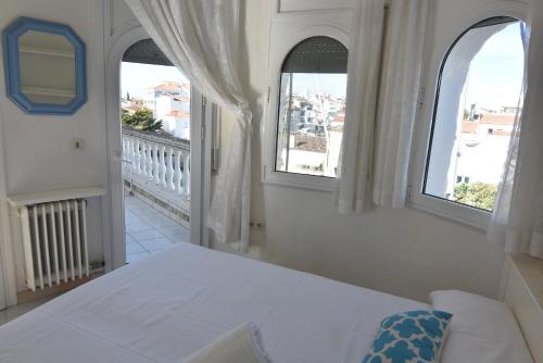 a white bedroom with two windows and a bed at RNET - Port Primer Empuriabrava in Empuriabrava