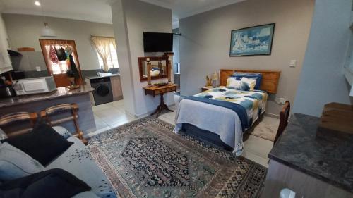 a bedroom with a bed and a living room at Granny at Umgeni in Pretoria