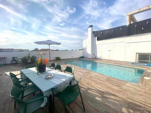 a table and chairs next to a swimming pool at Casa Campoamor By Solymar Holiday in Cogollos de Guadix