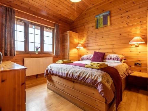 a bedroom with a bed in a wooden cabin at 3 Bed in Clovelly 00359 in Clovelly