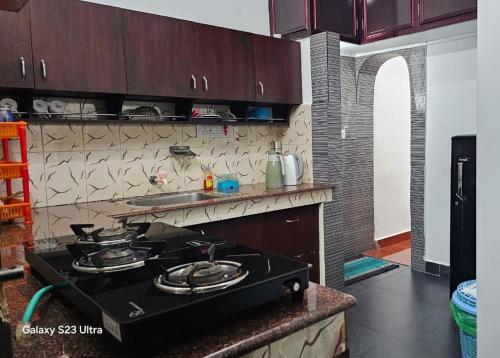 a kitchen with a stove top oven in a kitchen at The Signature Suites in Edappally
