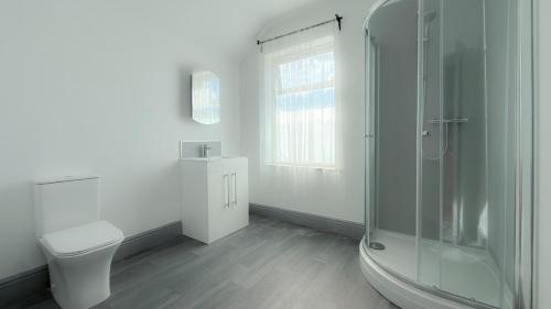 ein weißes Badezimmer mit Dusche und Toilette in der Unterkunft Hexthorpe House - By Sigma Stays in Doncaster
