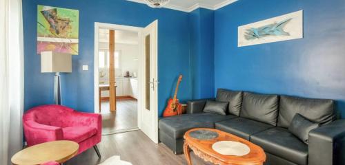 a living room with a couch and a red chair at Bright apartment in Lingolsheim for 6 people in Lingolsheim