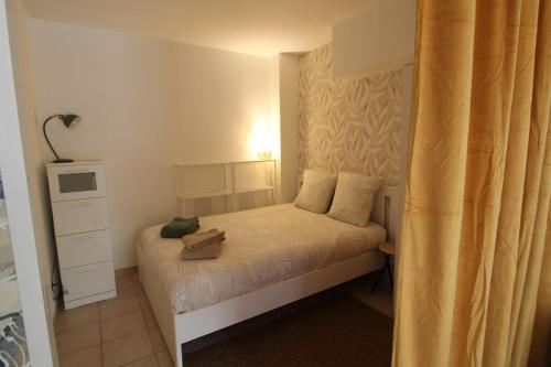 a small bedroom with a bed with a purse on it at Escapade Jurassienne-Terrasse & Sérénité in Lons-le-Saunier