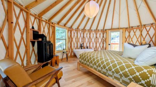 a bedroom with a bed and a tub in a yurt at Desolation Hotel Hope Valley in Markleeville