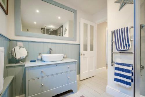 a bathroom with a sink and a mirror at Penrose in Downderry
