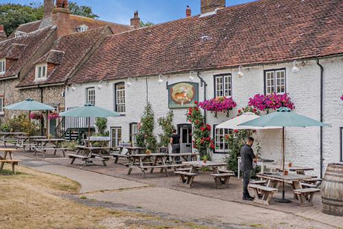 a man standing in front of a building with tables and umbrellas at The Garden Room in Eastbourne