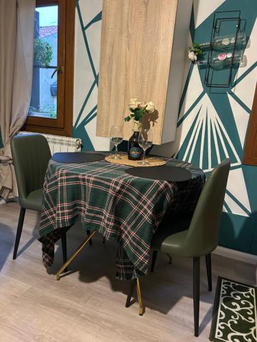 a table with chairs and a vase of flowers on it at Family House di Genny e Nicola small suite in Chioggia