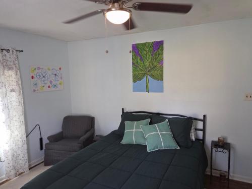a bedroom with a bed with a ceiling fan and a chair at Mellow Yellow in Jackson