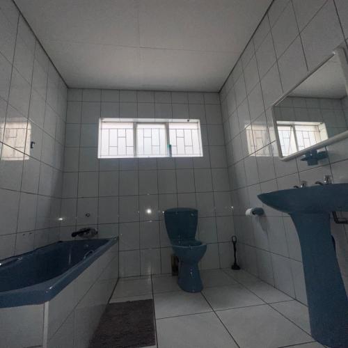 a bathroom with a tub and a toilet and a sink at MBT Lodge in Polokwane