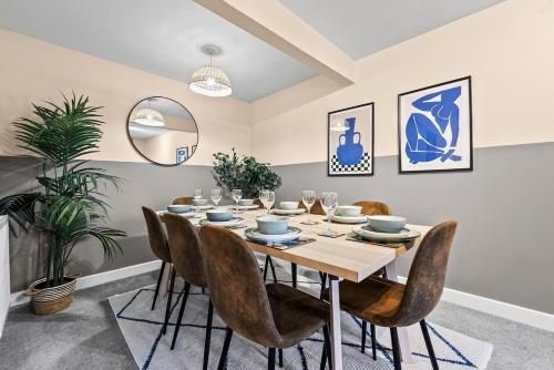 a dining room with a table and chairs at Chic 5-bedroom House in Basingstoke with Parking by PureStay in Basingstoke