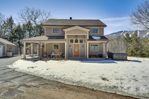 a house with a pile of snow in front of it at 1 Mi to Okemo Mtn Resort Ludlow Home with Hot Tub in Ludlow