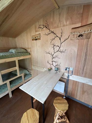 a room with a table and two bunk beds at ArdennenHut on Wheels in Durbuy
