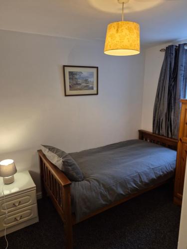 Un dormitorio con una cama, una lámpara y una mesa. en 3 bedroom apartment in Ulverston Cumbria, en Ulverston