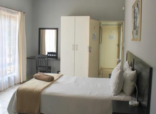 a bedroom with a large bed in a room at Rangers Airport Lodge in Benoni