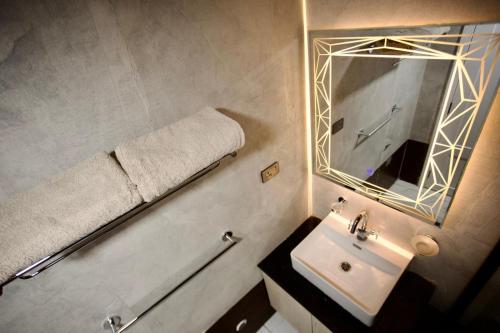 a bathroom with a sink and a mirror at Le Basilic Hotel Apartment & Spa in Addis Ababa