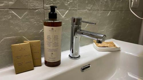 a bathroom sink with a bottle of soap and a faucet at Civico 49 Bed&Breakfast in Lecce