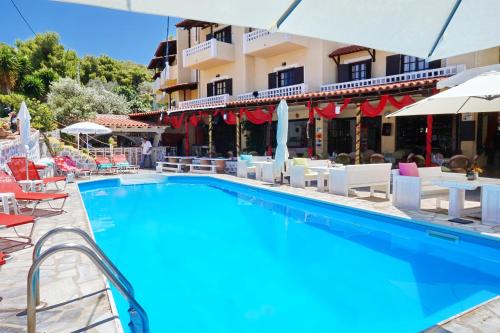 a pool at a hotel with chairs and umbrellas at Vasilaras Hotel in Skala