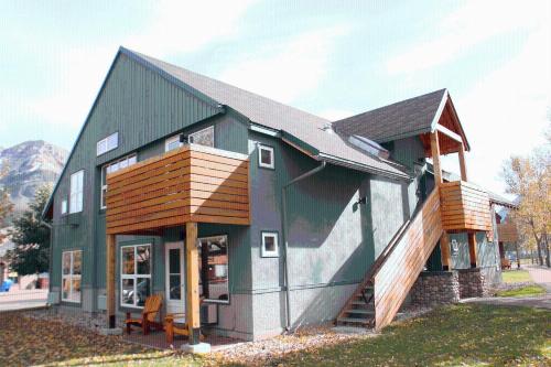 a small green house with a gambrel roof at Waterton Lakes Lodge Resort in Waterton Park