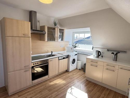 a kitchen with a sink and a stove top oven at Ferienwohnung Blinkfüer in Hinte