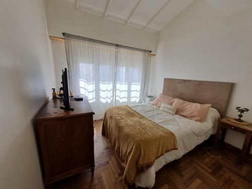 ArgentinaにあるDepto para 4 en Barrio Chauvínのベッドとドレッサーと窓のある寝室