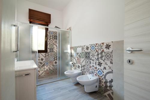 Un baño con dos inodoros y una ducha. en Villetta Althea, en Capilungo