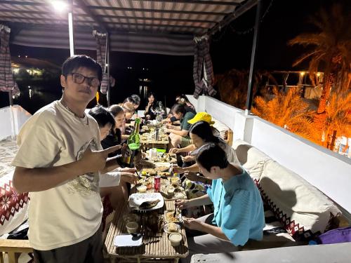 un grupo de personas sentadas en una mesa larga en Seko Kato Nile View Hostel, en Asuán