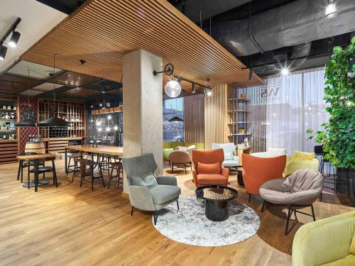 a lobby with chairs and tables in a room at Mercure Katowice Centrum in Katowice