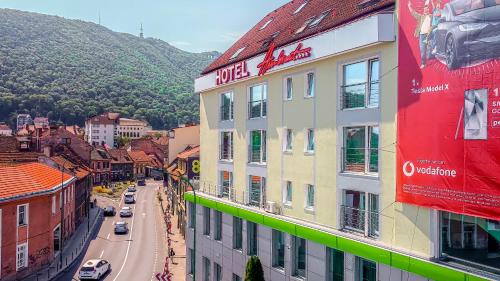 ein Gebäude mit einem Schild daran neben einer Straße in der Unterkunft Hotel Ambient in Braşov