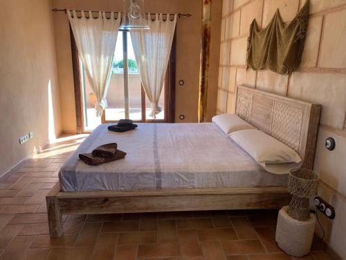 a bedroom with a bed in a room with a window at Ca Na Marina in Cala Llombards