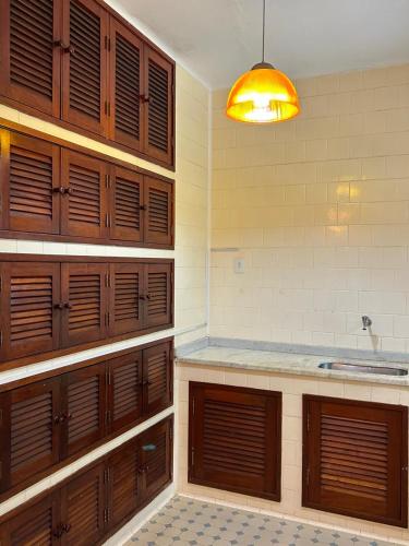a kitchen with wooden cabinets and a light at Casa em Penedo - Itatiaia in Itatiaia