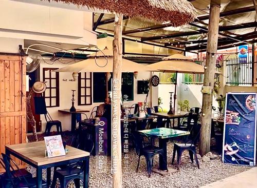 a restaurant with tables and chairs and an umbrella at Ocean Breeze Hostel by Daily Sweet in Moalboal