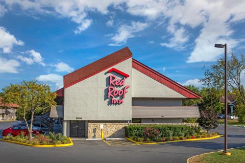 a building with a rock roof firm sign on it at Red Roof Inn Milwaukee Airport Oak Creek in Oak Creek