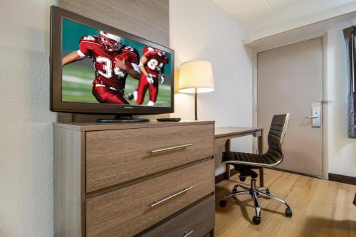 a room with a desk and a tv on a dresser at Red Roof Inn Durham - Duke Univ Medical Center in Durham