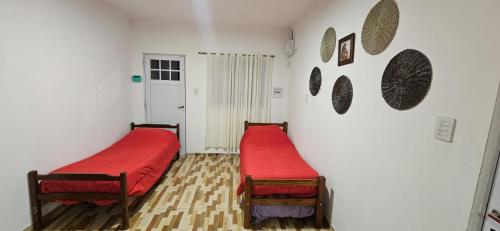 2 camas en una habitación con sábanas rojas en Hermosa quinta Sauce, en Sauce Viejo