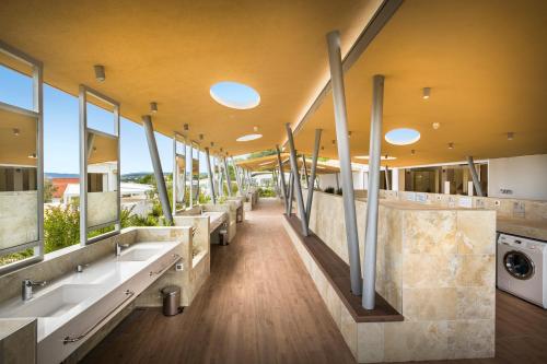 a bathroom with sinks and a row of mirrors at Valamar Camping Krk in Krk