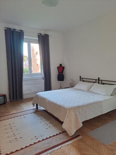 een slaapkamer met een groot bed voor een raam bij Serenissima Retro Apartment in Muggia